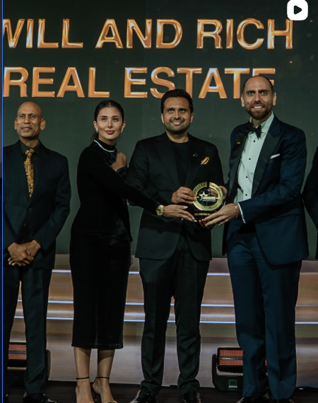 Wael Handous receiving an industry award on stage in Dubai